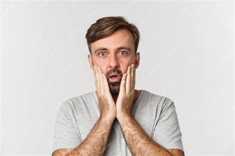 Premium Photo Close Up Of Shocked Adult Guy Holding Hands On Face Gasping And Looking At
