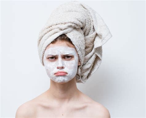 Nude Woman With White Cream On Her Face And A Towel On Her Head Stock