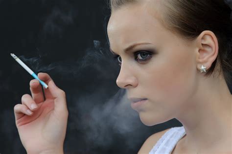 Young Woman Smoking Cigarette Smoke Passing Through Her Nose Stock