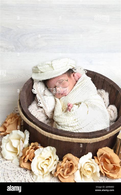Newborn Cute Boy Covered With Towel And Cap Sleeping In Wooden Round