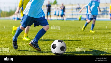 Young Boys Playing Football Soccer Game Running Players In Blue And