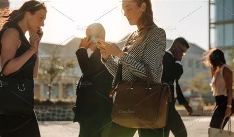 People Busy Using Mobile Phone Featuring Background Building And