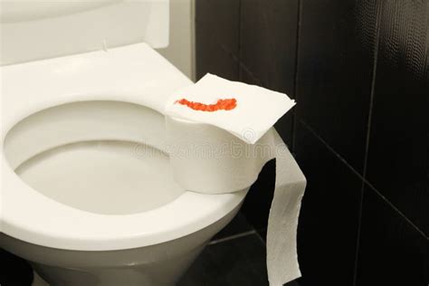 A Roll Of Toilet Paper With Blood Lies On The Toilet Stock Image
