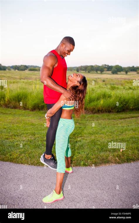 Young Woman Training By Lifting Up Boyfriend Stock Photo Alamy