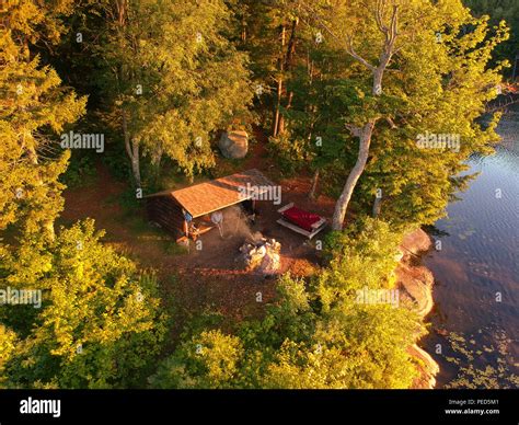 Aerial Drone Image Of A Log Cabin Lean To Shelter And Campfire On A