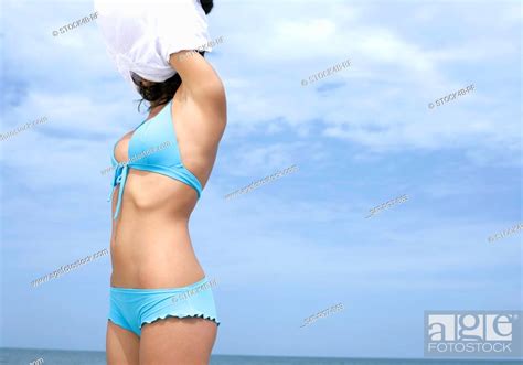 Woman In Bikini On The Beach Taking Off Tee Shirt Stock Photo Picture And Royalty Free Image