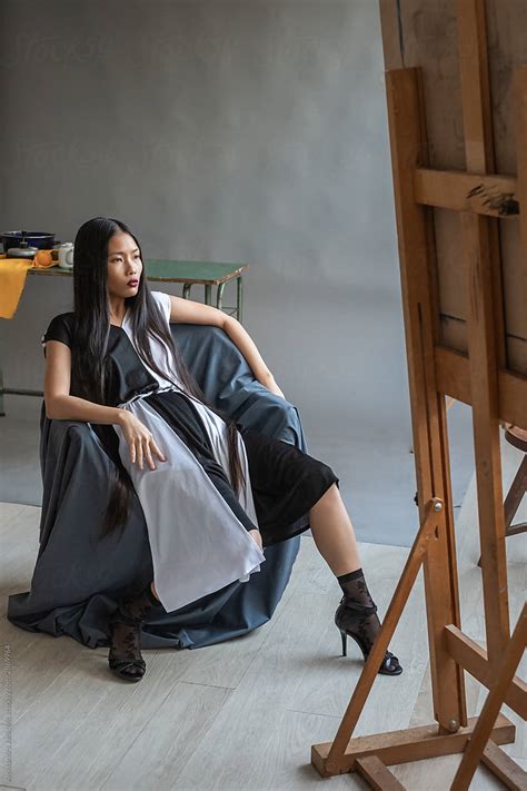 Fashionable Asian Woman With Long Hair Posing In The Art Studio By Stocksy Contributor