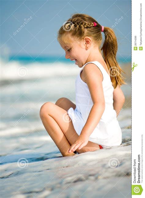 Маленькая девочка на пляже стоковое изображение изображение насчитывающей усаживание