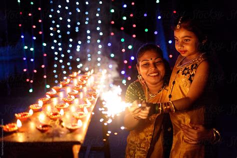 Mother And Daughter Having Fun With Sparkler By Stocksy Contributor