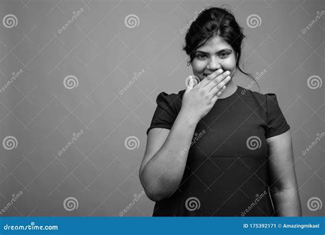 Young Beautiful Overweight Indian Woman Against Gray Background Stock