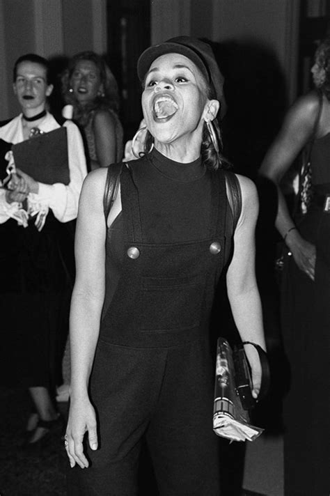 Black And White Photograph Of Woman In Overalls Laughing With Other