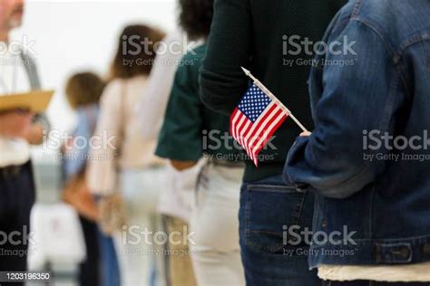 Diverse Group In Line To Vote One Holds American Flag Stock Photo