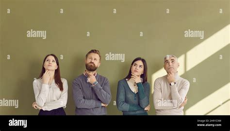 Group Of Serious People Thinking Over Question And Looking Up At Copy
