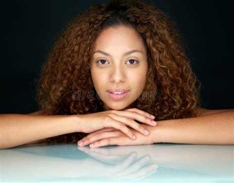 Portrait Of A Beautiful Young Woman With Curly Hair Looking At Camera