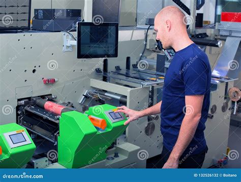 Worker Next To The Printing Machine Inputs The Data By Pressing The