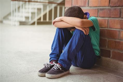 Upset lonely child sitting by himself on the elementary school grounds - Evergreen Psychotherapy ...