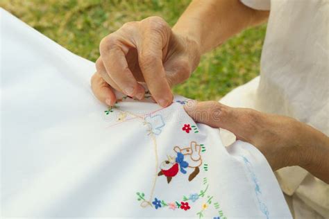An Old Woman Is Embroidering On The White Blanket Stock Image Image
