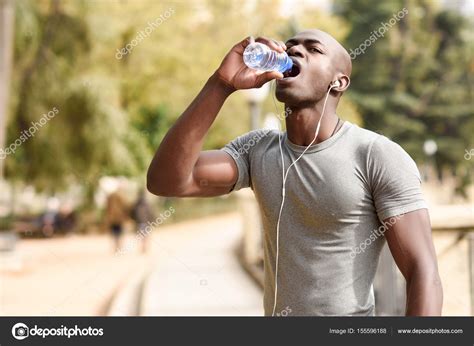 Young Black Man Drinking Water Before Running In Urban Backgroun Stock