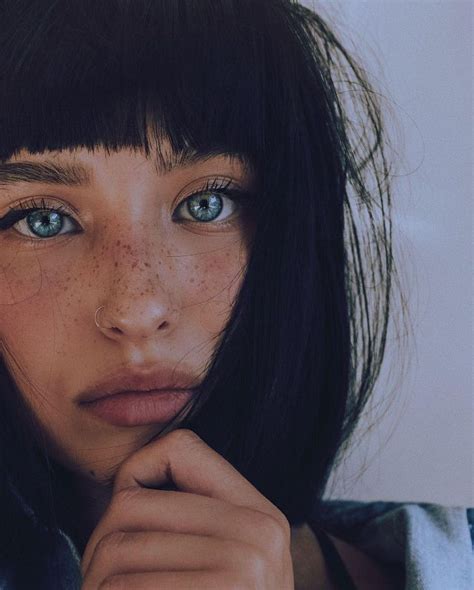 A Woman With Freckled Hair And Blue Eyes Holding Her Hand To Her Face
