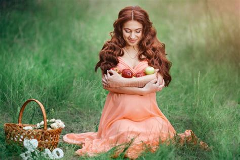 beautiful pregnancy concept brunette happy woman sitting on grass with curly hair on nature