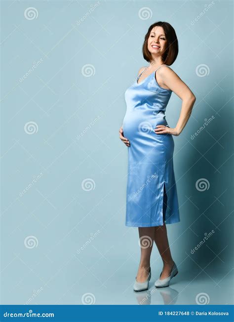 Brunette Pregnant Woman In Blue Silk Dress Or Nightie She Smiling Put