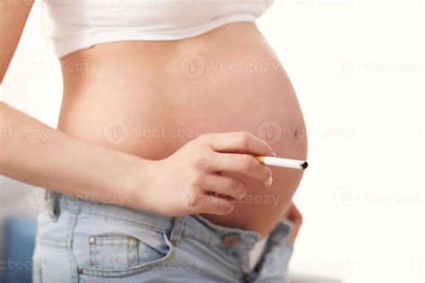 Close Up Of Pregnant Woman Smoking Cigarette At Home Stock