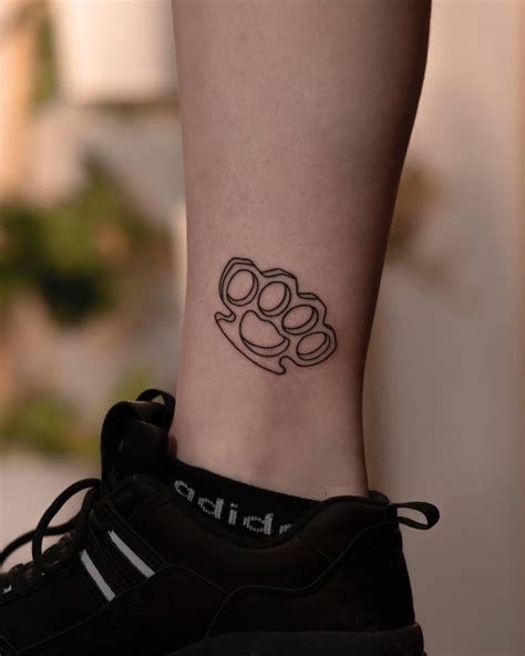 Hand Poked Brass Knuckle Tattoo Located On The Ankle