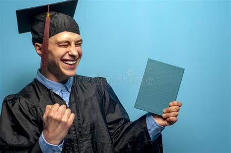 Hombre Graduado Con Las Lentes Que Soporta Un Diploma Foto De Archivo