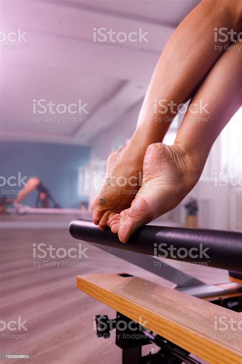 Close Up Of Barefoot Woman Exercising On A Pilates Machine Stock Photo