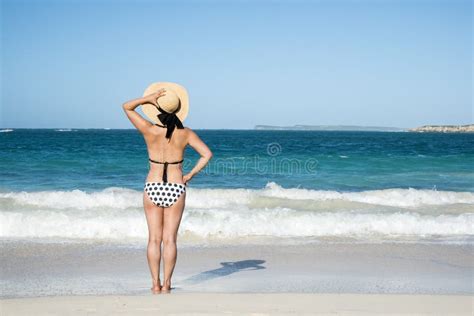 Back View Of A Woman In Polka Dot Bikini Standing On A Beach 2 Stock