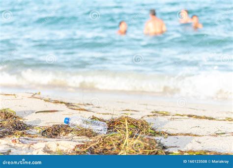 Close Up Image Of Empty Plastic Water Bottle On Dirty Beach Filled With