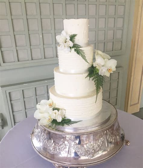 buttercream wedding cake with fresh orchids and ferns etoile bakery
