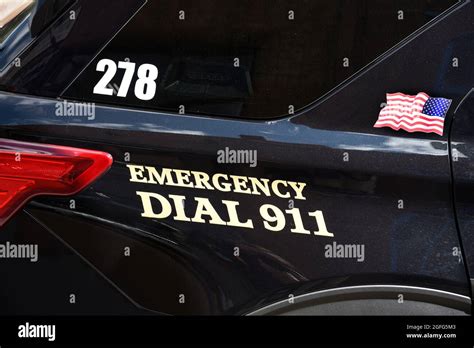 A Police Car With Emergency Dial 911 Parked At An Outdoor Art Show In