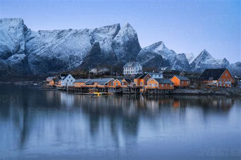 Houses Of Reine Village Located On Sea Shore Against Frozen Mountains