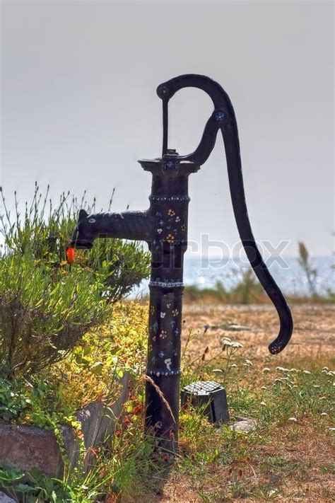 What are the parts of a well pump? Old fashioned iron water pump with sky in the background ...