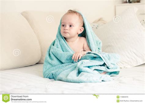 Toned Image Of Little Baby Boy Covered In Towel Sitting On Bed Stock