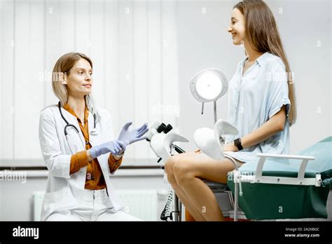 Gynecologist Preparing For An Examination Procedure For A Pregnant Woman Sitting On A