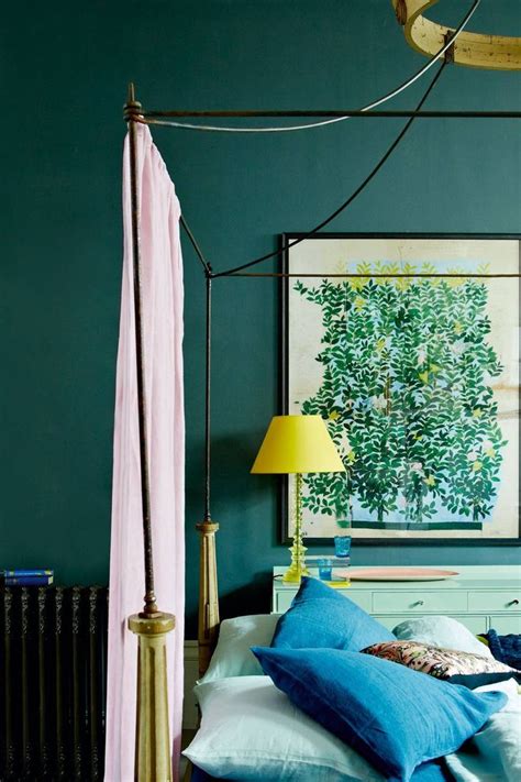 A Bedroom With Green Walls Blue Bedding And Yellow Lamps On The