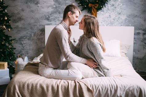 Premium Photo Young Sweet Couple In Love On Bed On Christmas Time