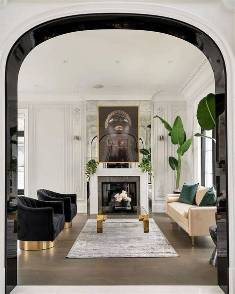 The Living Room Is Decorated In White And Black With Gold Accents On
