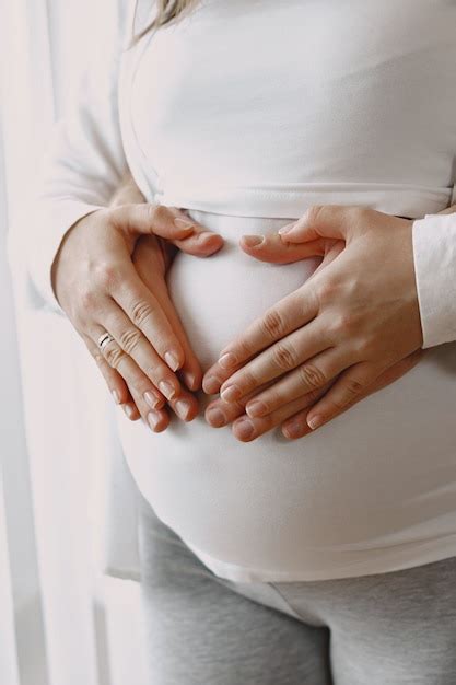 grávida com roupas leves mãos na barriga de uma mulher grávida família pela janela foto premium