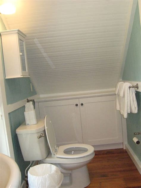 An elegant attic bathroom with a wallpaper statement wall, a grey bathtub, elegant chairs and potted blooms (aston matthews). 23+ Attic Bathroom Designs | Bathroom Designs | Design Trends - Premium PSD, Vector Downloads