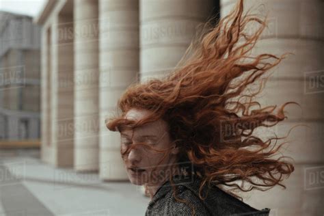 Wind Blowing Hair Of Caucasian Woman Near Pillars Stock Photo Dissolve