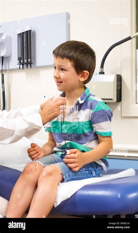 Doctor Examining Boy At Clinic Stock Photo Alamy