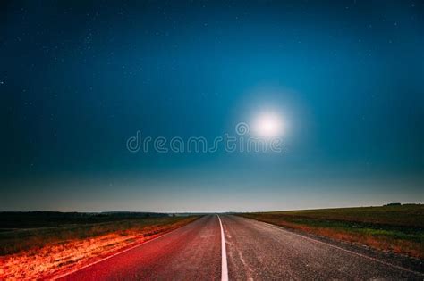 Night Starry Sky With Moon Above Country Asphalt Road In Countryside