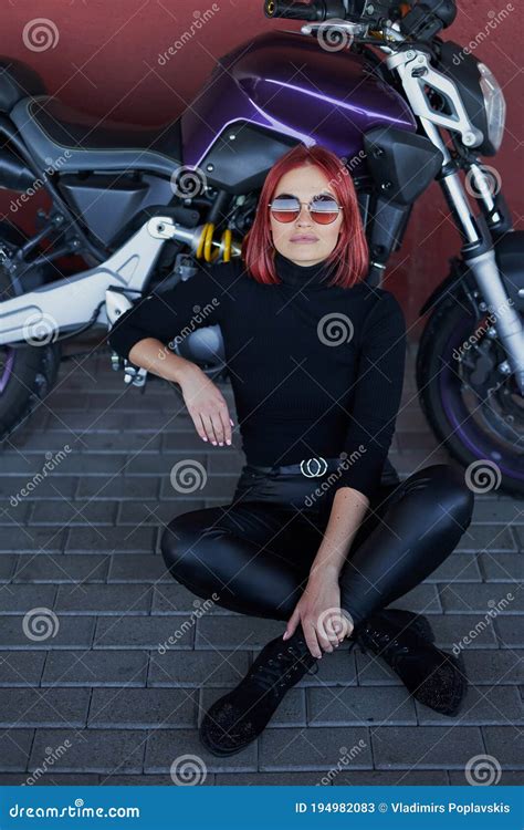 cute redhead woman sitting and posing with her motorcycle stock image image of serious