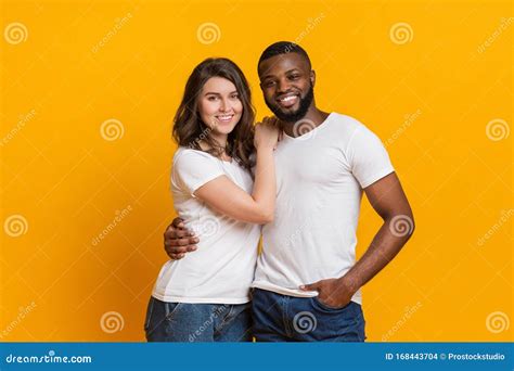 Portrait Of Romantic Interracial Couple Cuddling And Posing Together