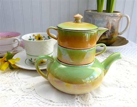 A Table Topped With Cups And Saucers Covered In Green Glaze Next To
