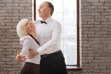 Lively Elderly Dance Couple Enjoying Tango At The Ballroom Stock Image