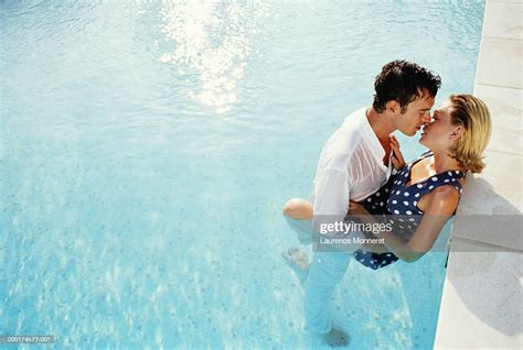 Couple Kissing In Swimming Pool Fully Clothed Elevated View High Res